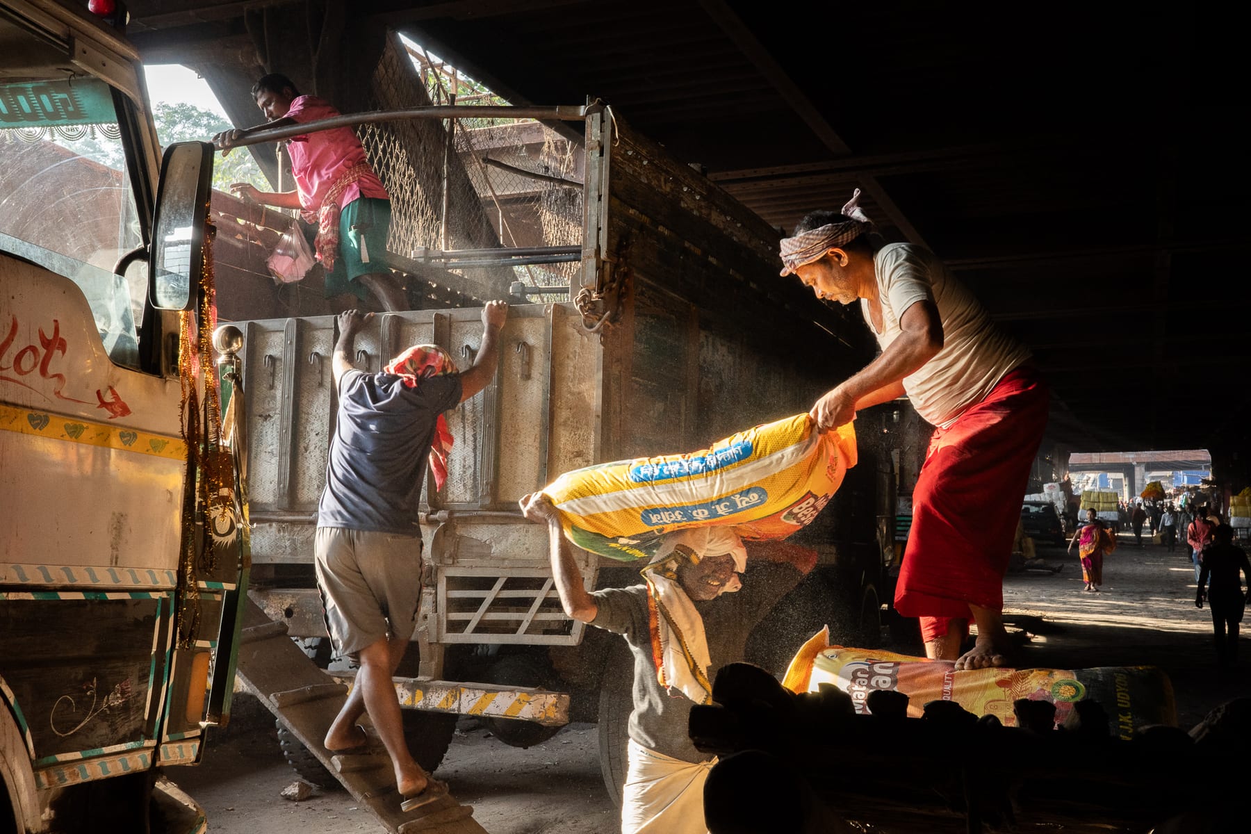 Street workers unloading sacks from a truck